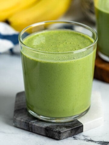 Collard greens smoothie in a short glass.