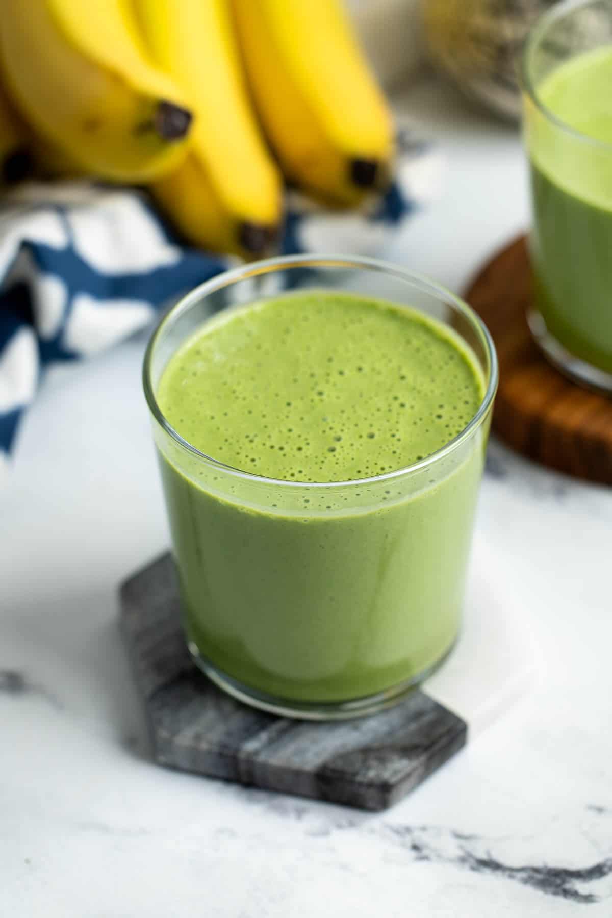 Collard greens smoothie in a short glass.