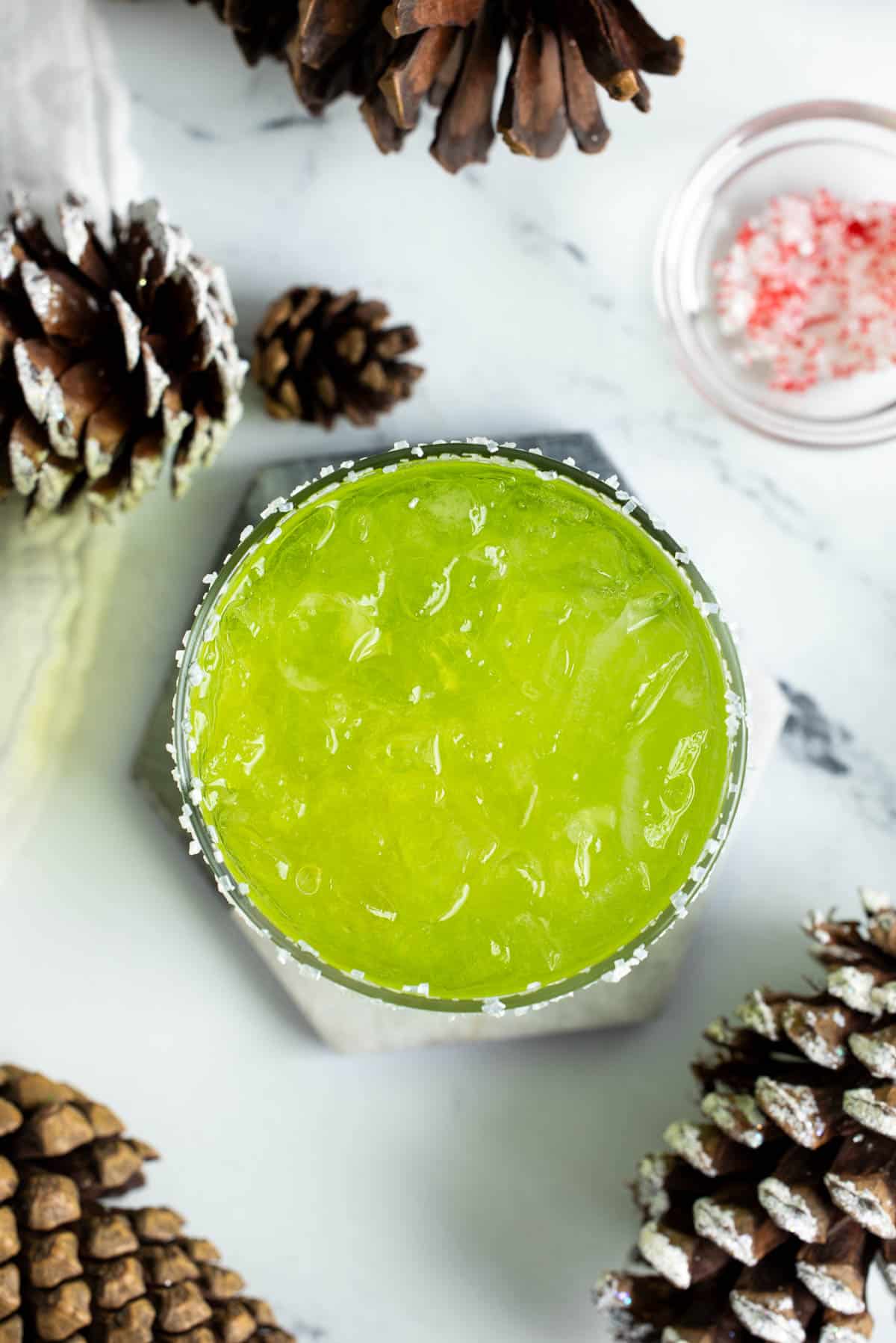 A grinch cocktail on a marble coaster.