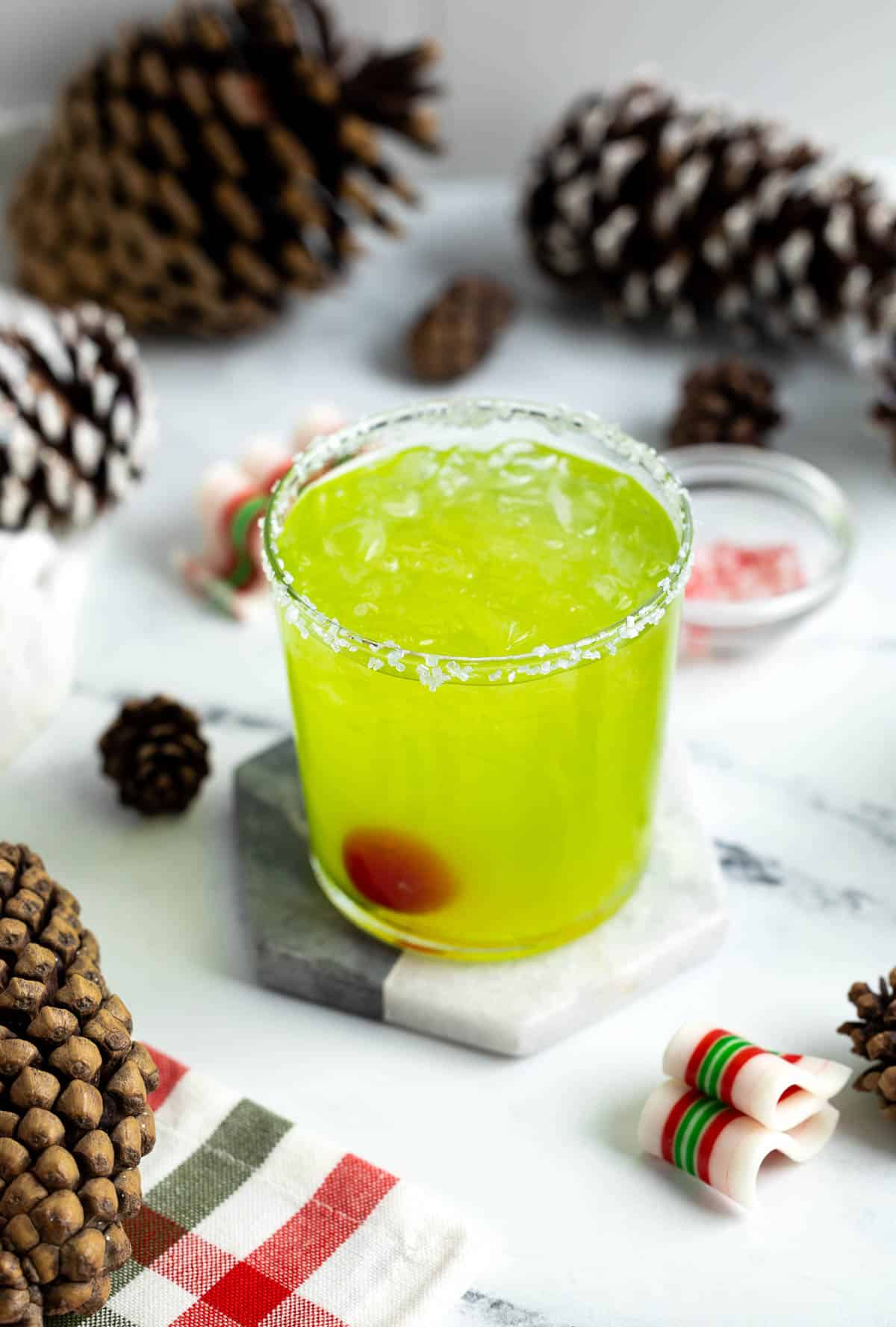 A grinch cocktail on a marble coaster.