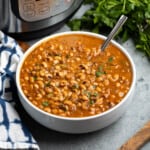 A serving bowl of seasoned black eyed peas in front of an Instant Pot.