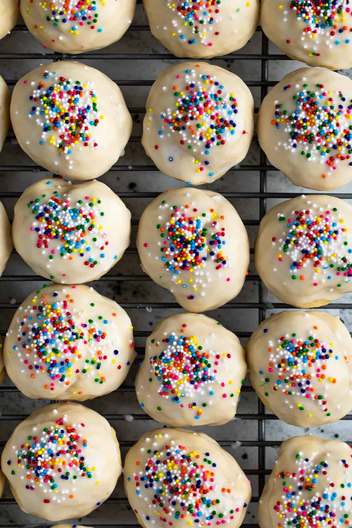 Glazed anise cookies lined up on a wire rack.