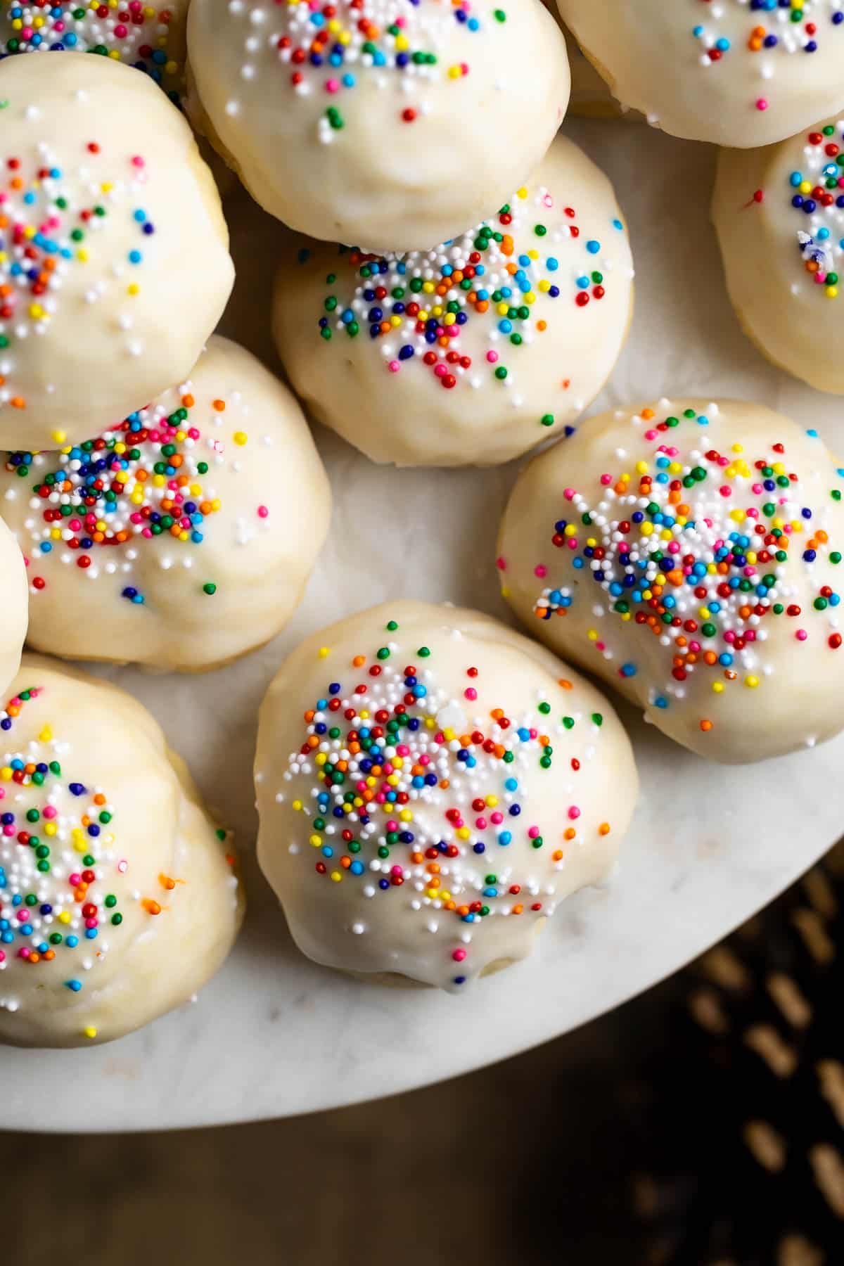 Italian anise cookies on a round marble serving board.