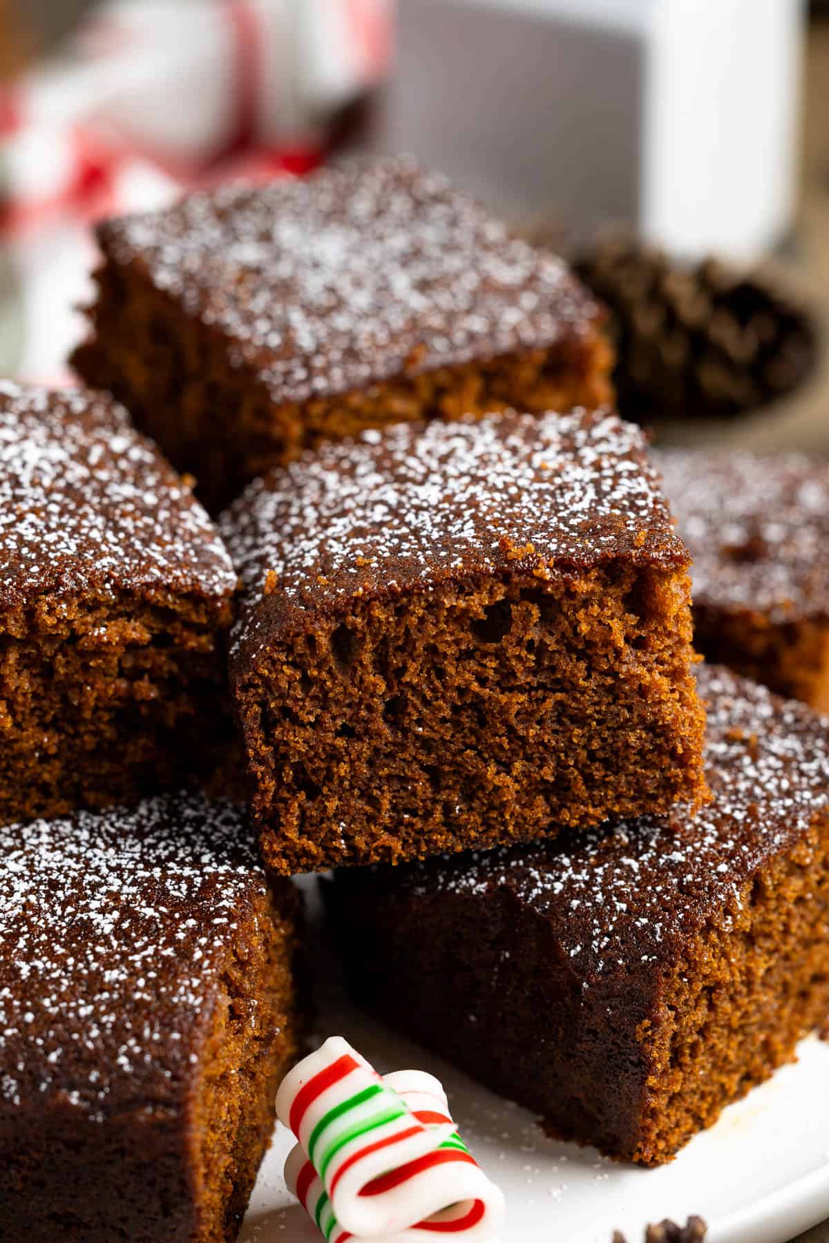 Stacked pieces of old-fashioned gingerbread dusted with powdered sugar.