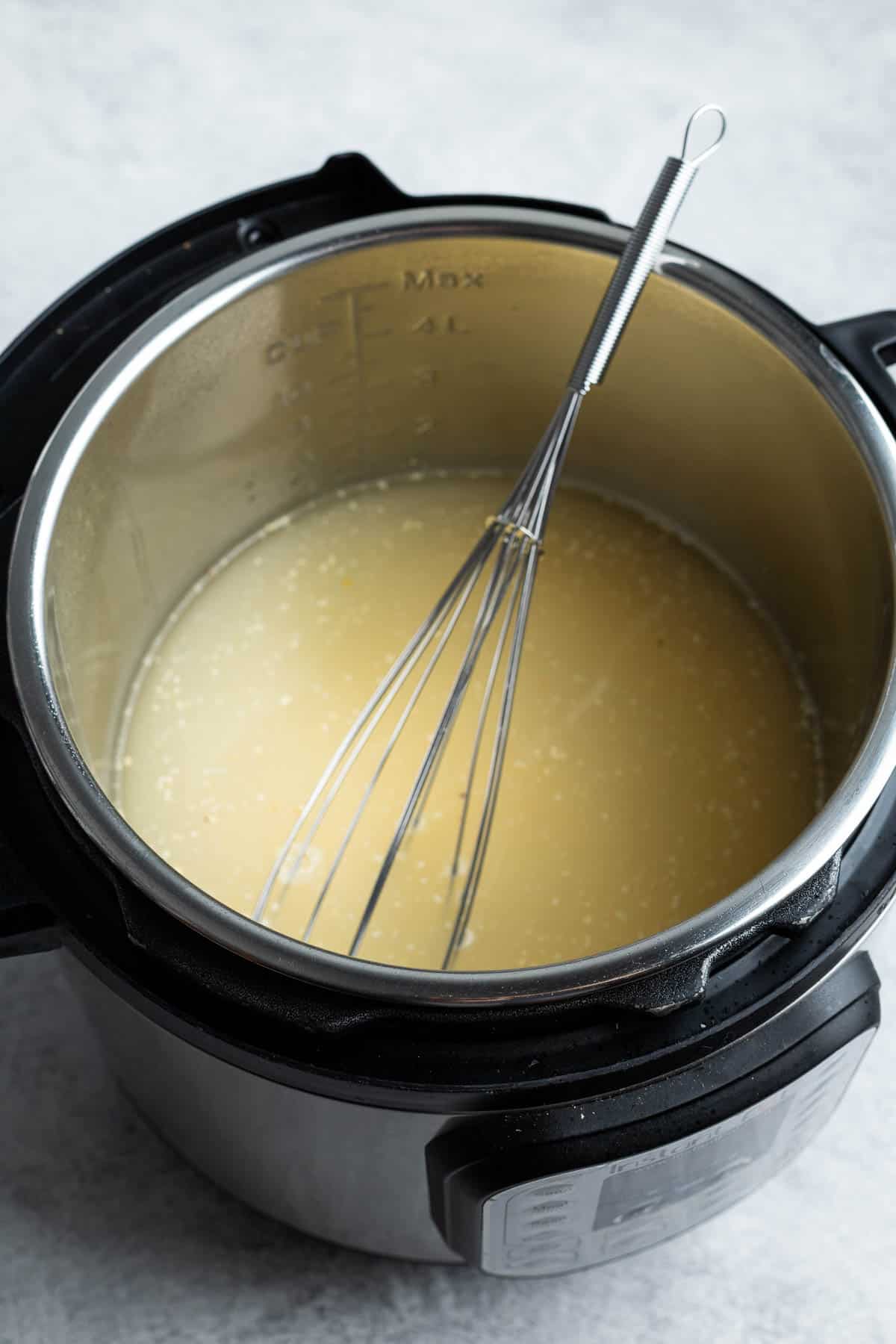 Whisking polenta and water in the Instant Pot.