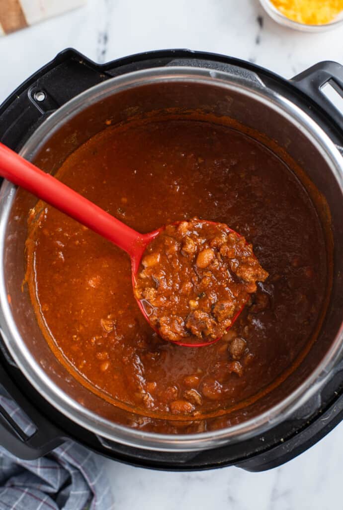 Turkey chili being ladled out of the Instant Pot.