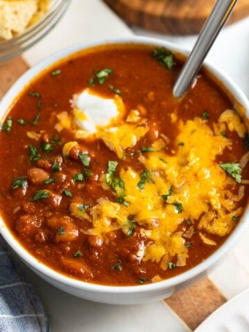 A bowl of turkey chili topped with sour cream, cheese, and cilantro.