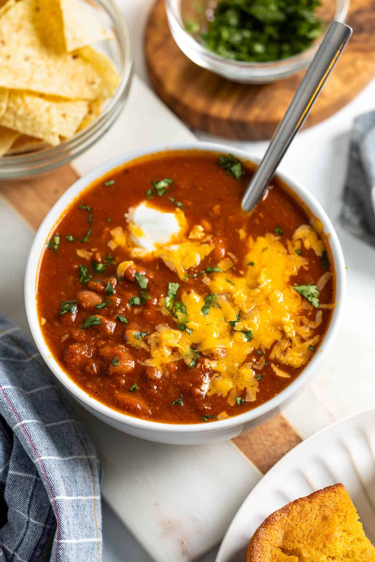 A bowl of turkey chili topped with sour cream, cheese, and cilantro.