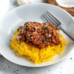 A serving of spaghetti squash bolognese in a shallow bowl.