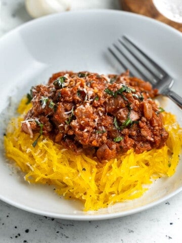 A serving of spaghetti squash bolognese in a shallow bowl.