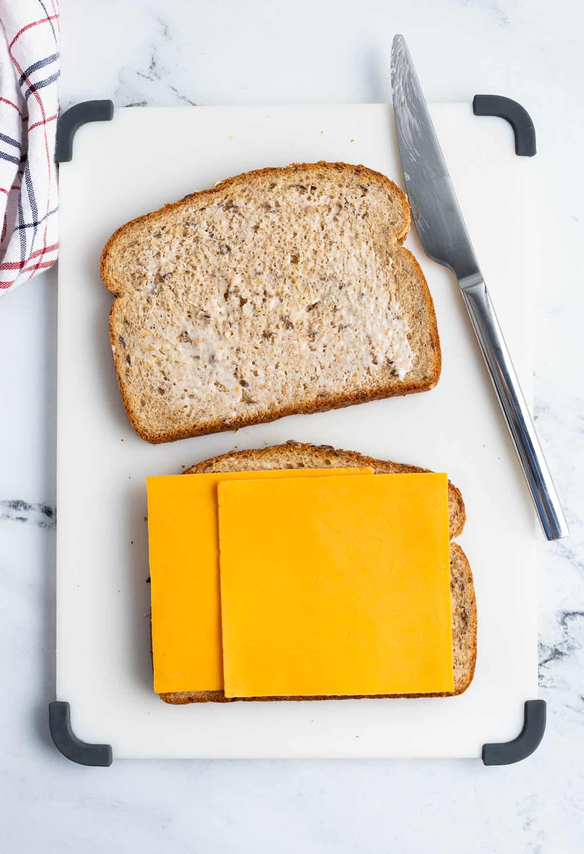 A grilled cheese sandwich in the process of being assembled.