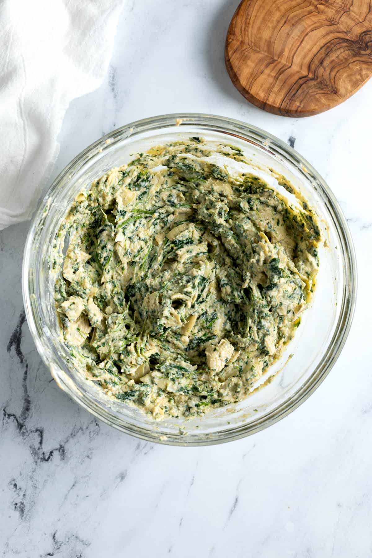 Stirred together spinach artichoke dip in a mixing bowl.
