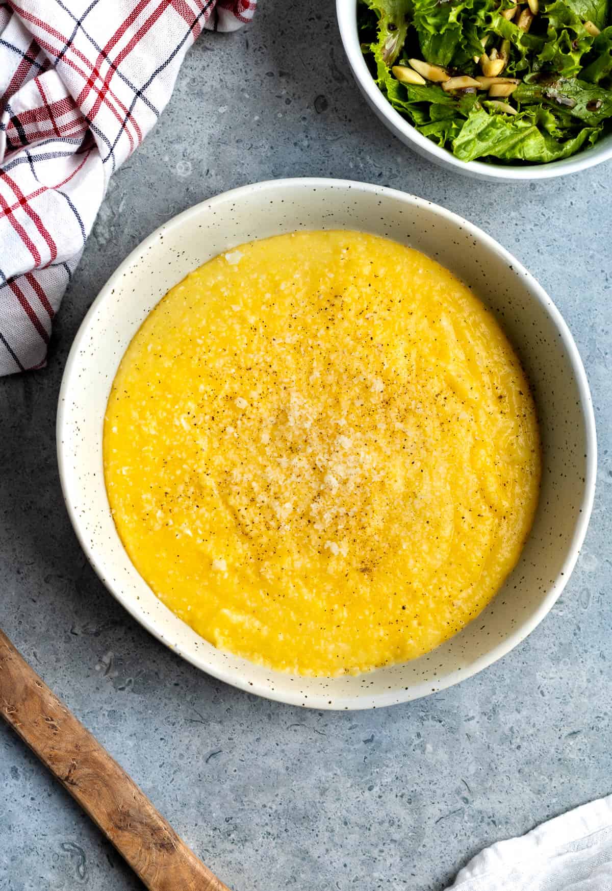 Instant Pot polenta in a bowl topped with pepper and Parmesan.