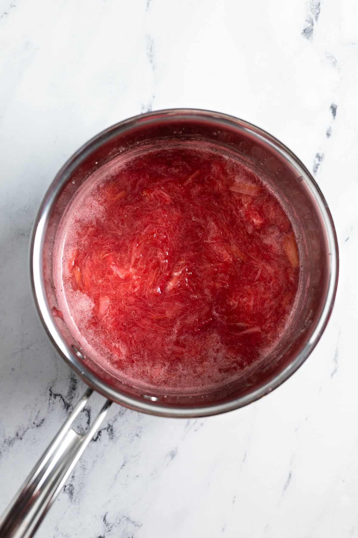 Cooked down stewed rhubarb in a saucepan.