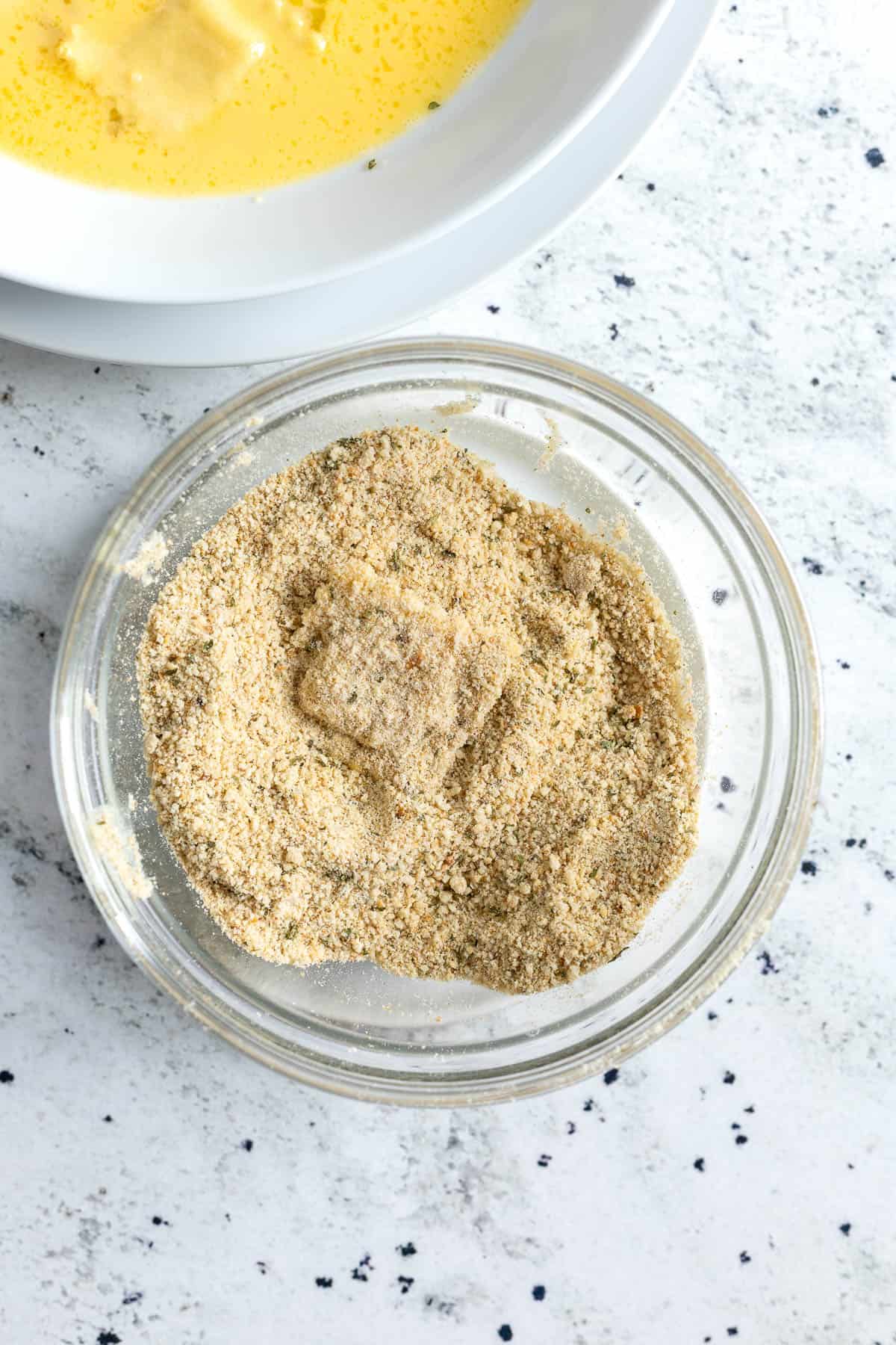 Ravioli coated in a bowl of breadcrumbs.