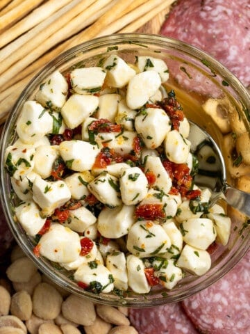 A bowl or marinated mozzarella in the middle of an antipasto platter.