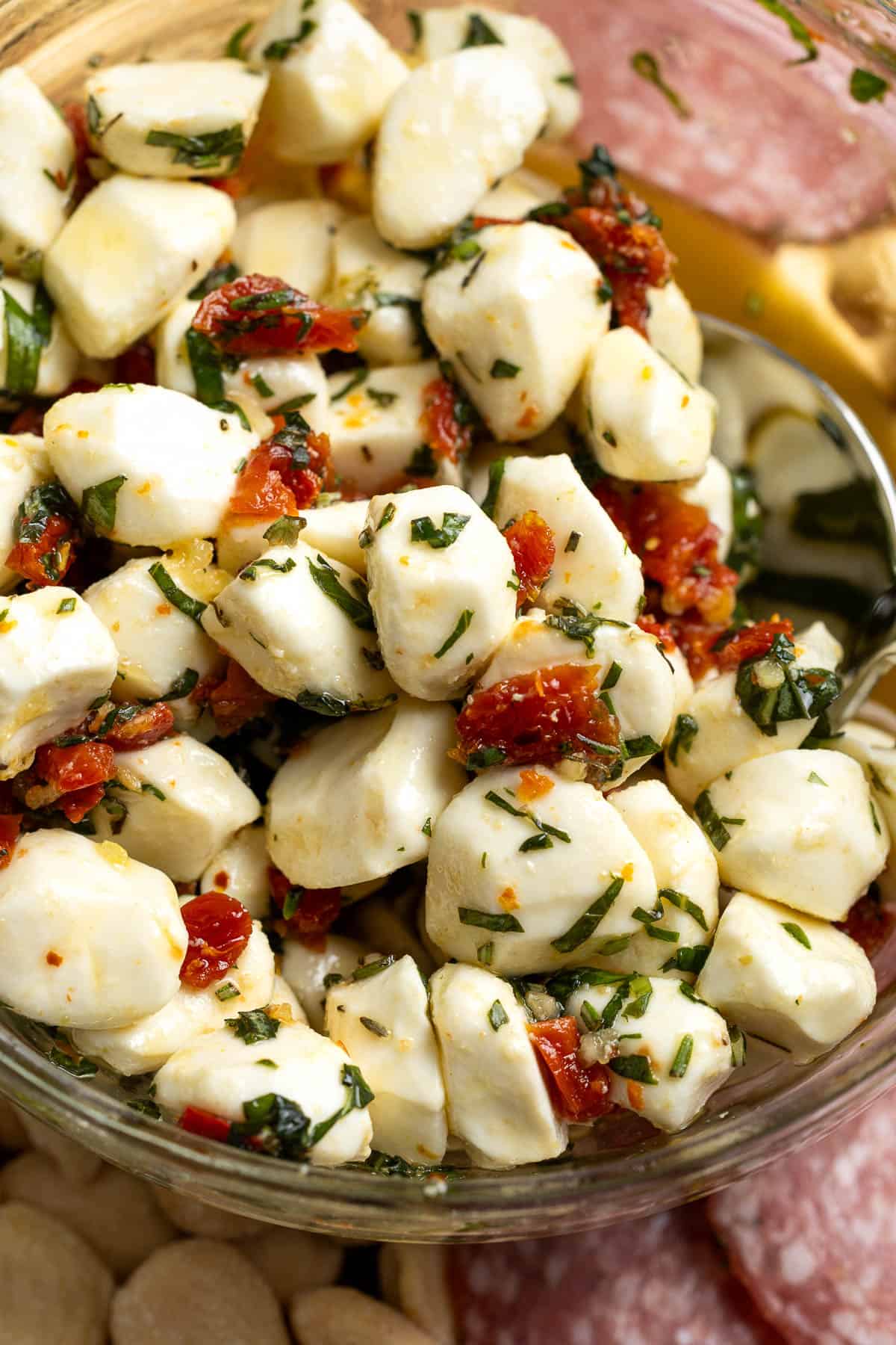 Fresh mozzarella balls coated in olive oil, herbs, sun-dried tomatoes, and seasonings.