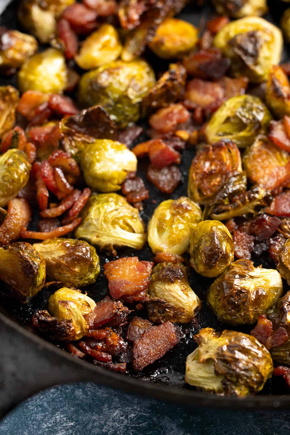 Roasted maple brussels sprouts and bacon in a skillet.