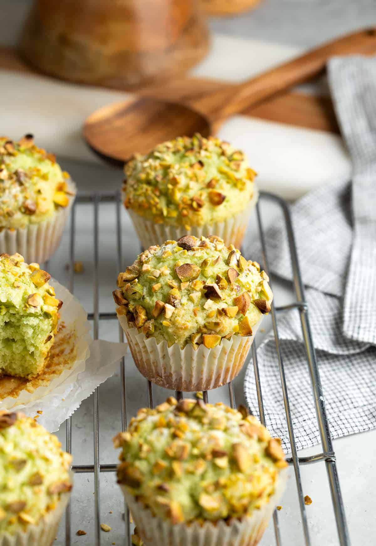 Pistachio muffins cooling on a wire rack.