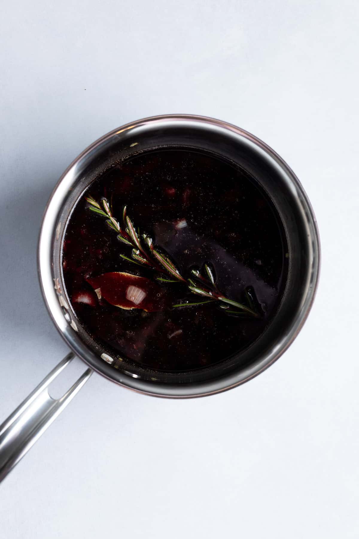 Red wine and herbs added to the pan.