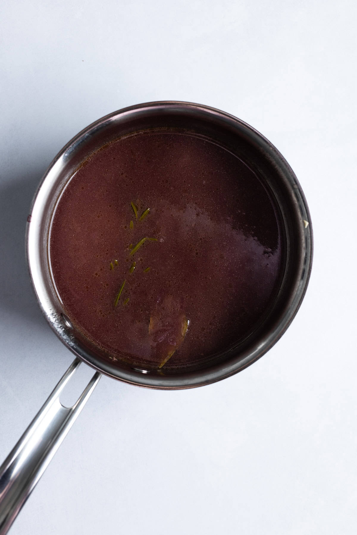 Beef broth added to the jus in progress and reduced.
