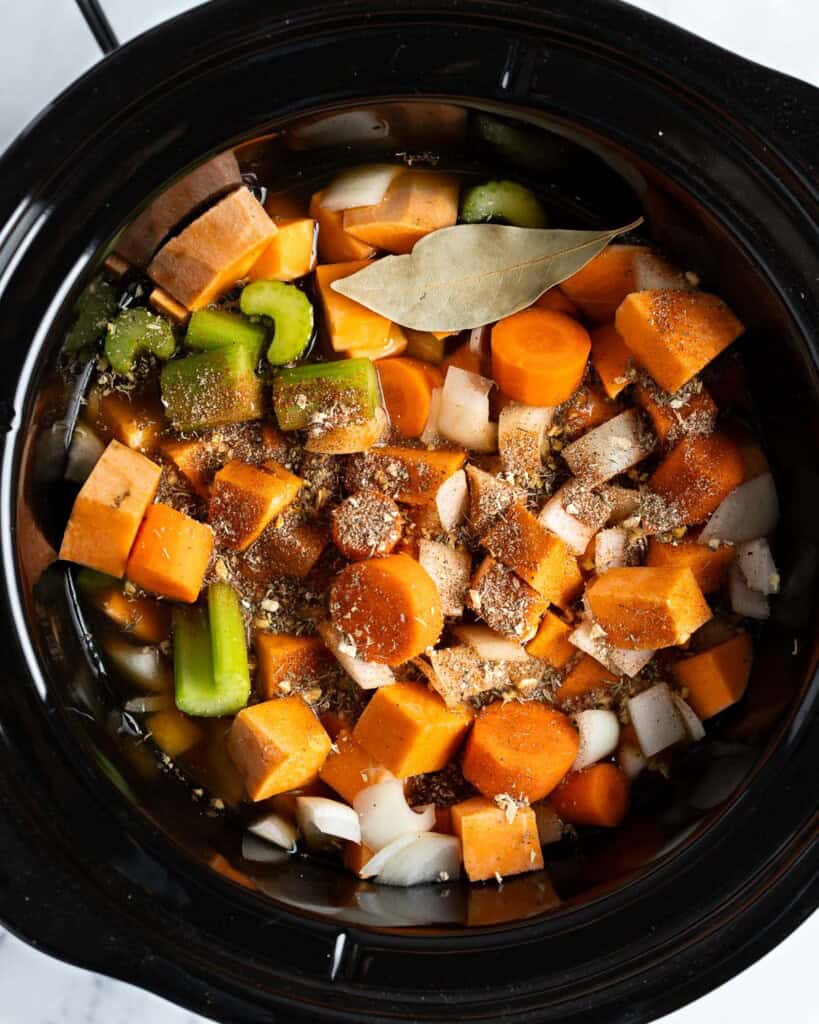 All soup ingredients (except coconut milk) added to a round slow cooker insert.