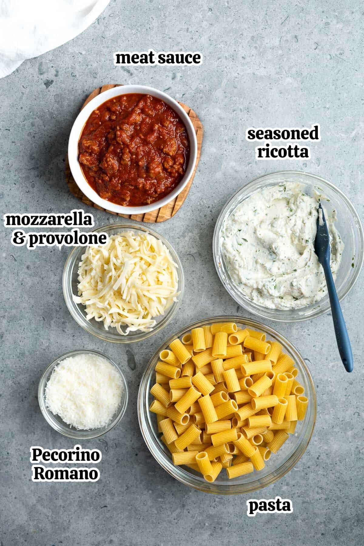 Text-labeled pasta al forno recipe ingredients in separate bowls.