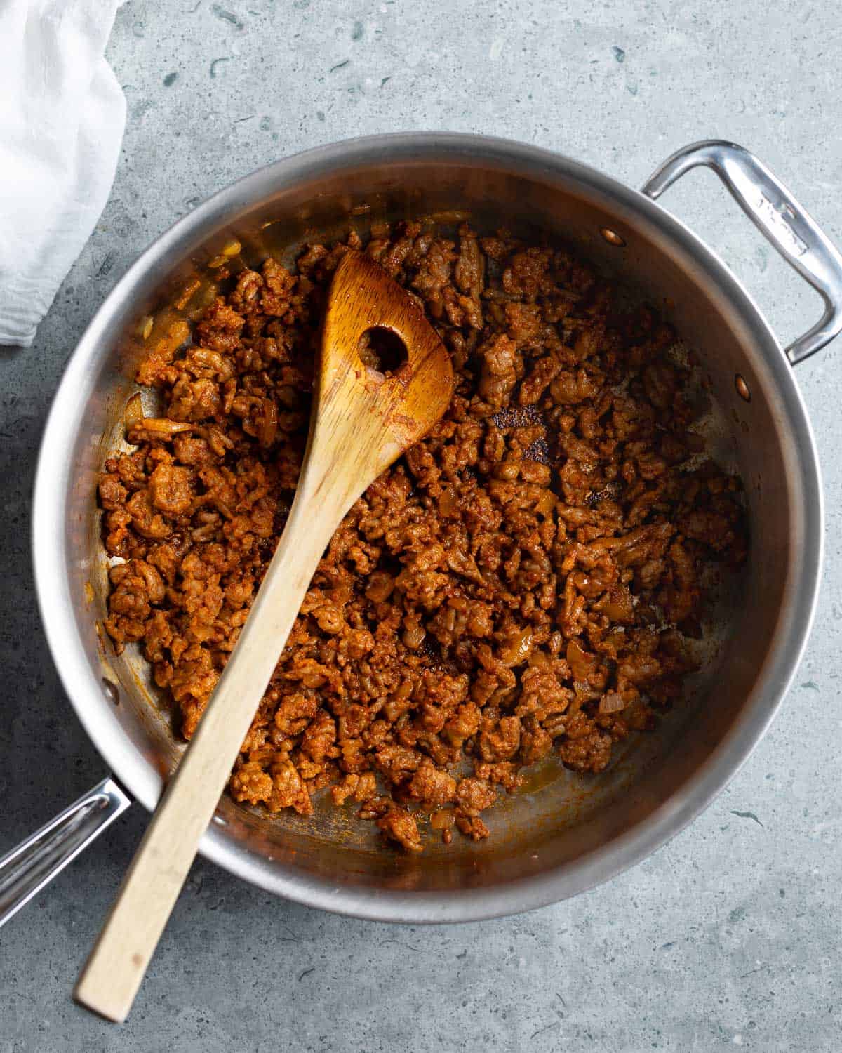 Cooked onion, ground Italian sausage, garlic, and tomato paste in a large pan.
