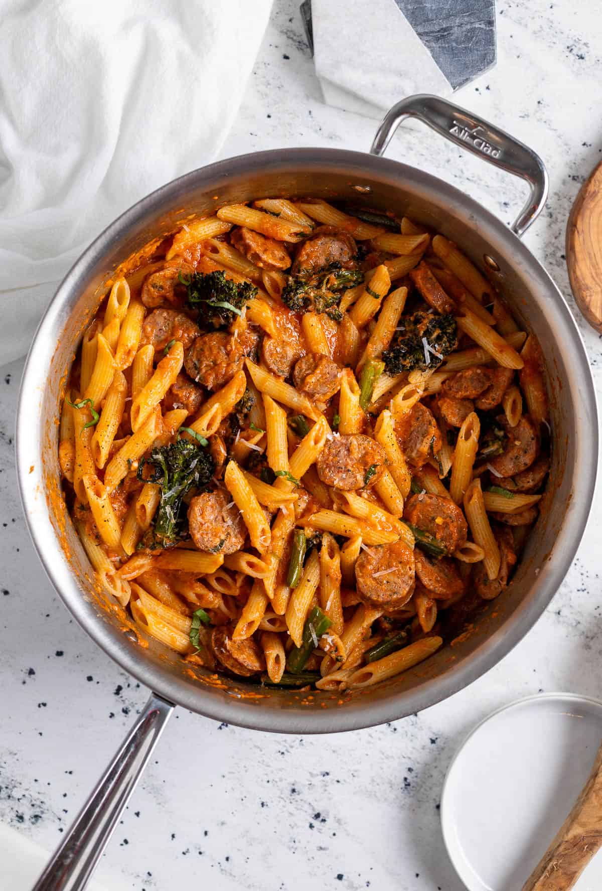 Chicken sausage pasta with broccolini in a large pan.