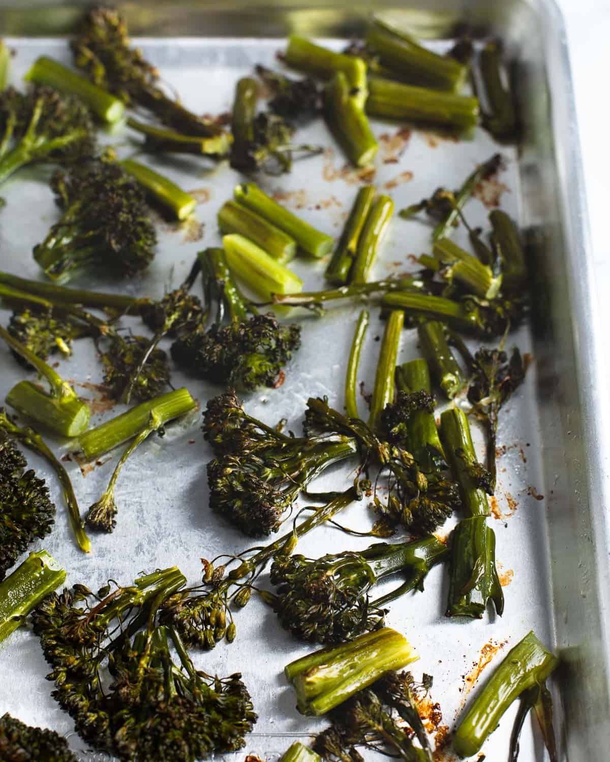 Chopped roasted broccolini on a sheet pan.