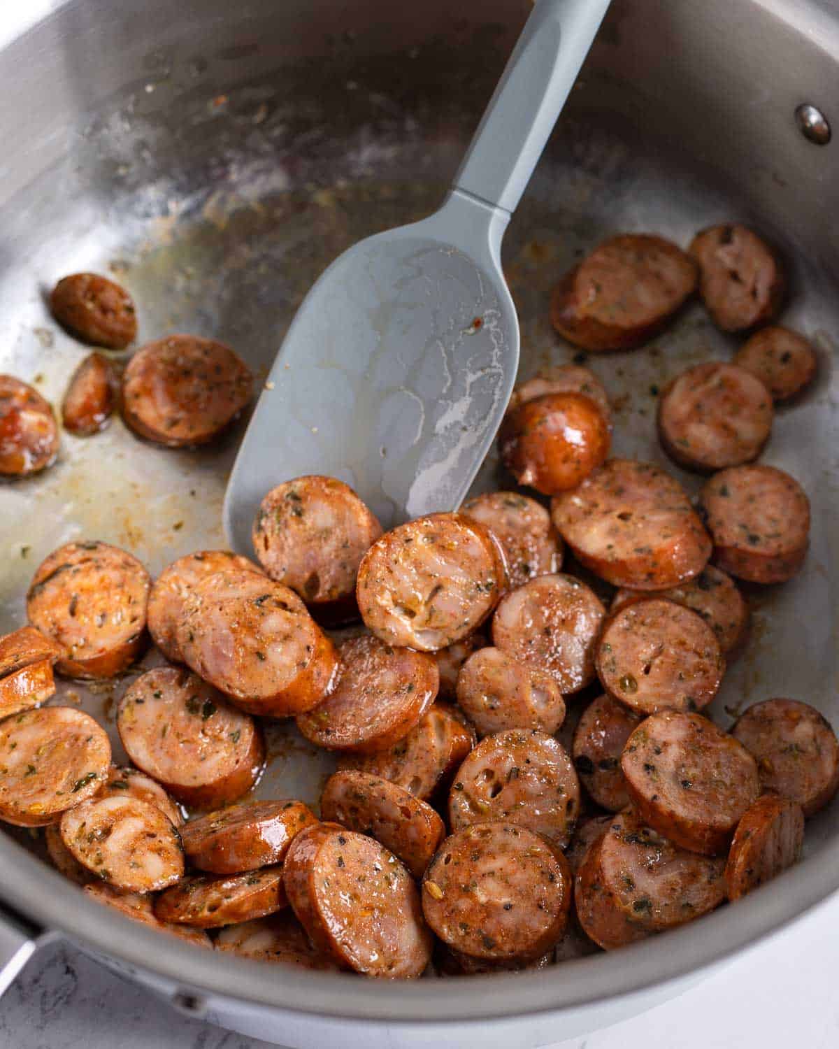 Chicken sausage rounds browned in a pan.
