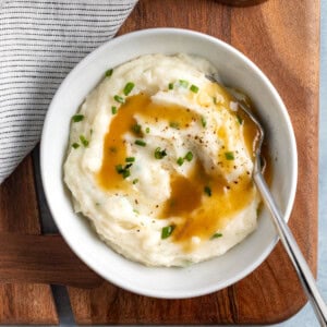 A small bowl of mashed potatoes topped with gravy.