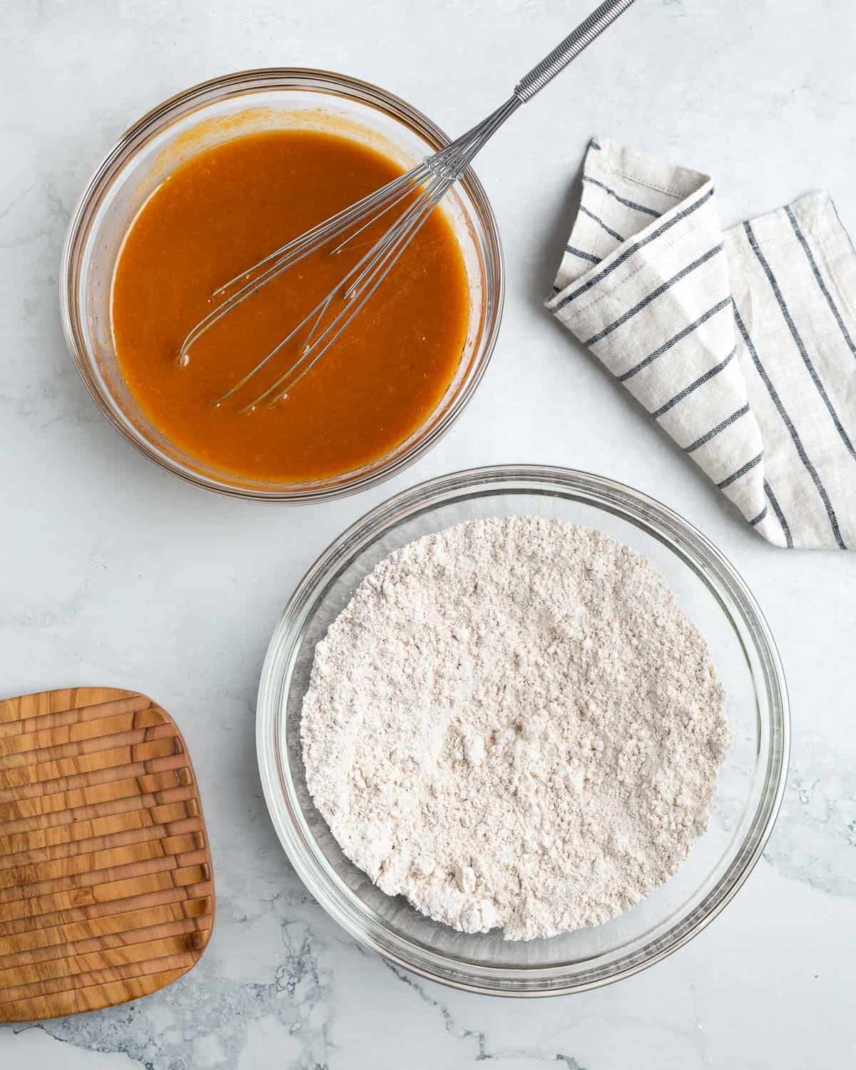 Two bowls of separately mixed wet and dry recipe ingredients.