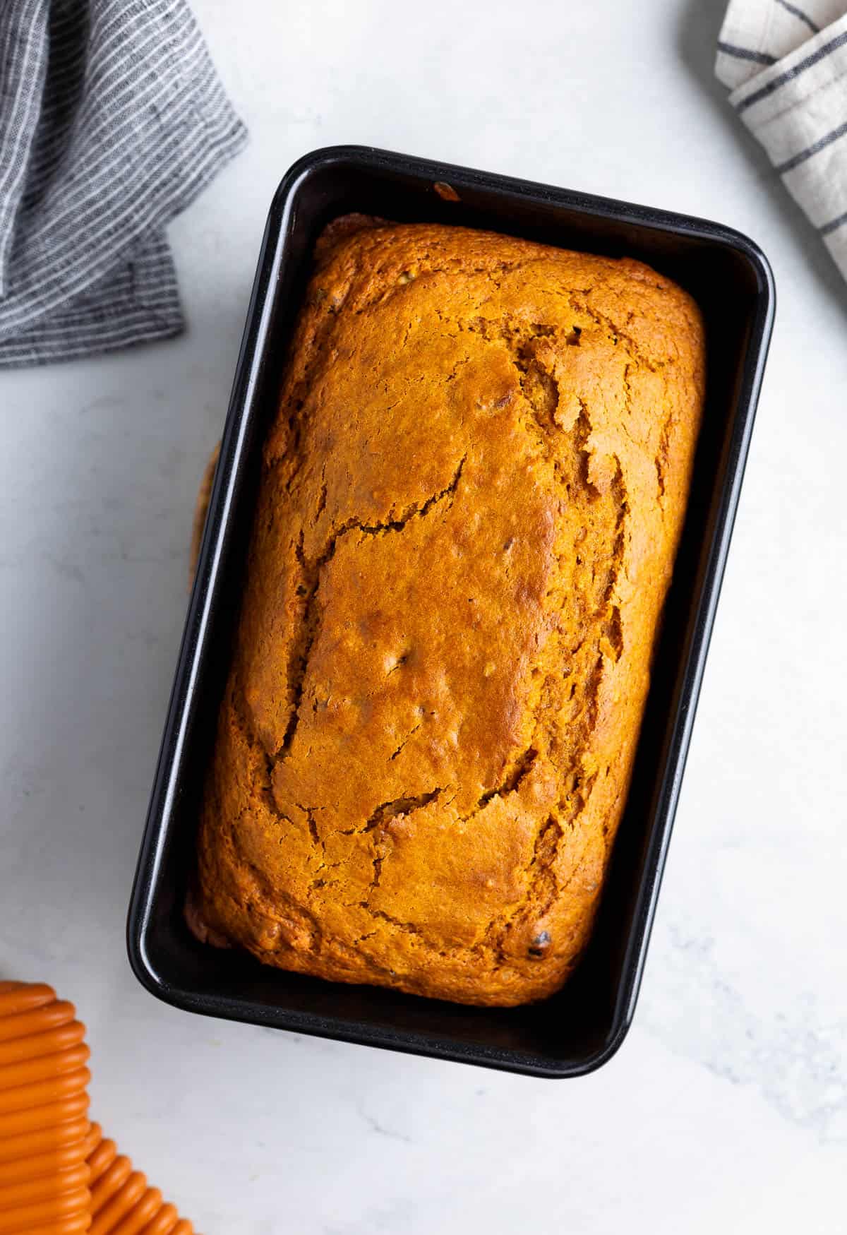 A baked loaf of Bisquick pumpkin bread in a loaf pan.