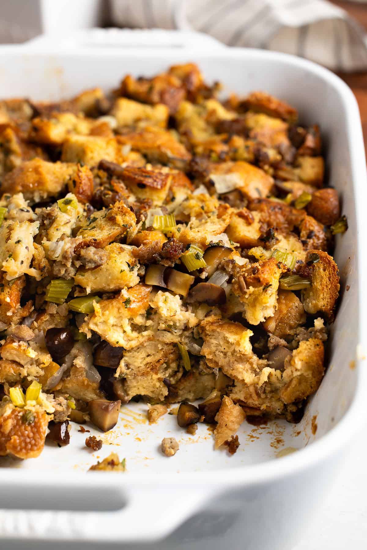 A half-served dish of sausage chestnut stuffing showing the side profile.
