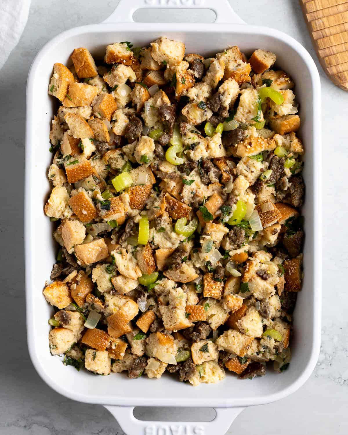 The assembled stuffing in a large baking dish before being cooked.