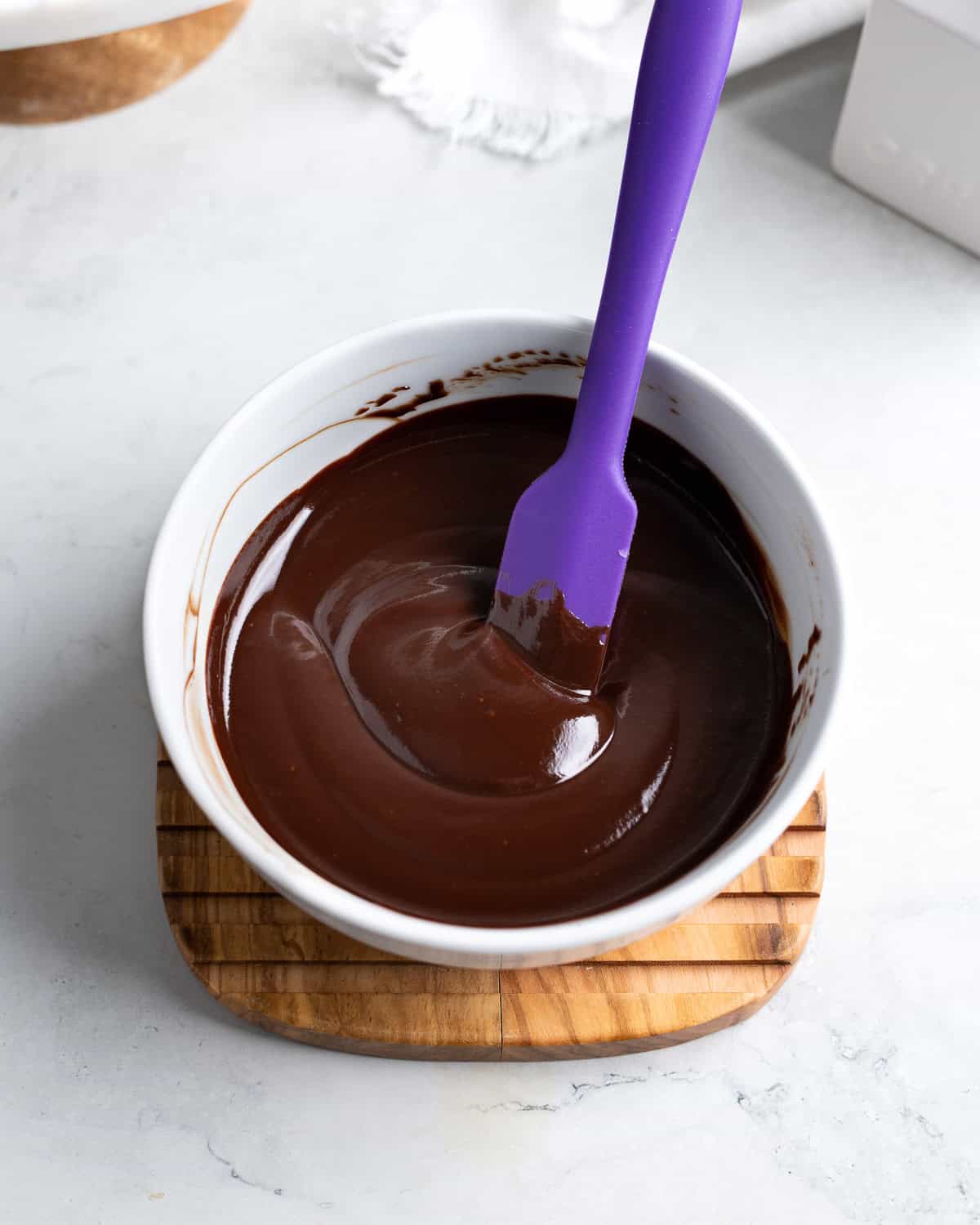 Melted and smooth chocolate ganache in a bowl.
