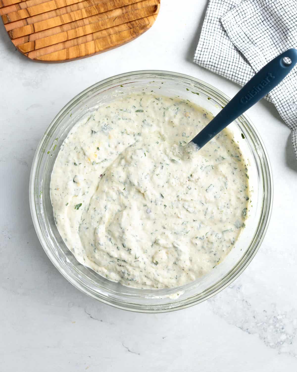 The seasoned ricotta and mascarpone filling in a bowl with a spatula.