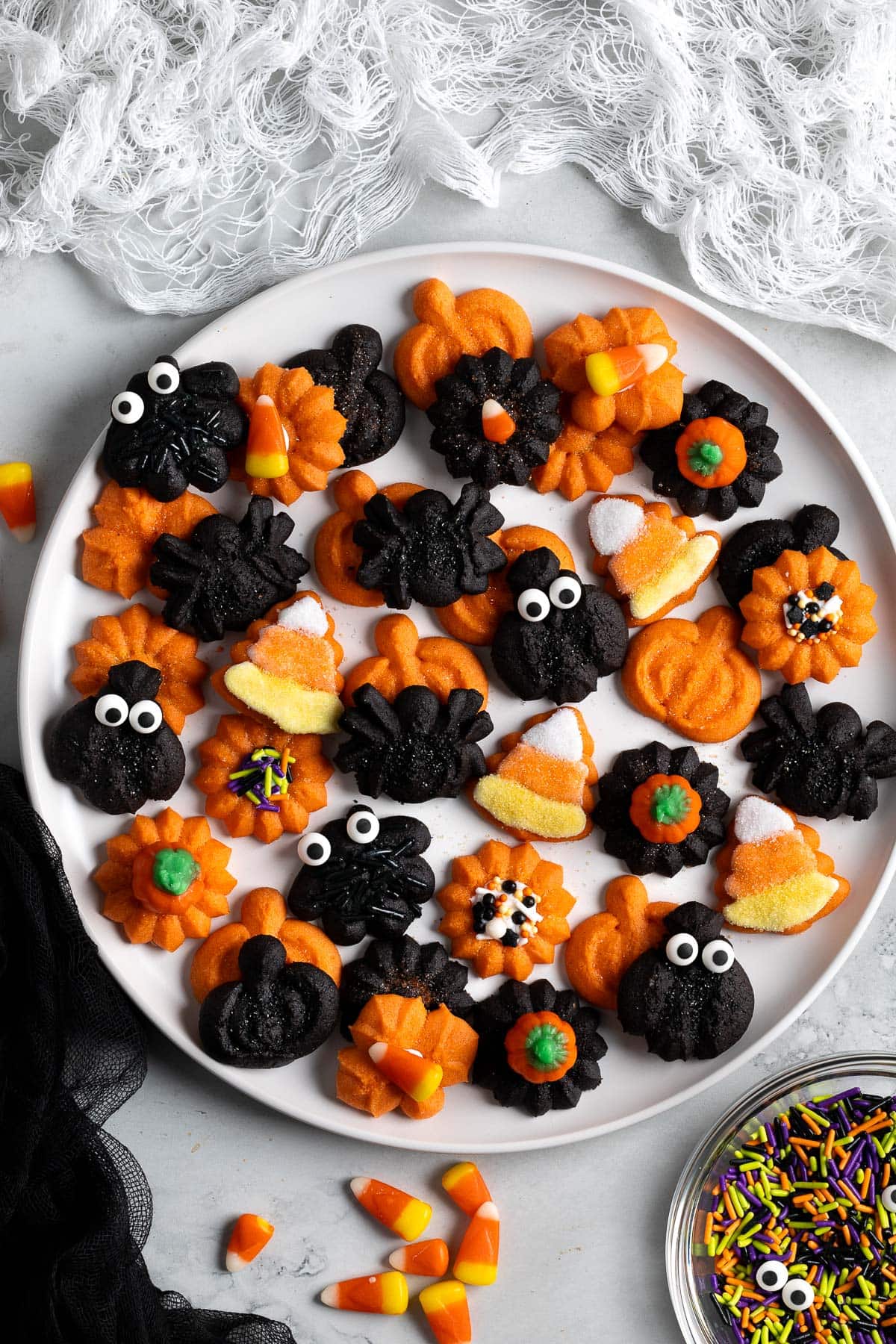 An assortment of decorated Halloween spritz cookies on a plate.