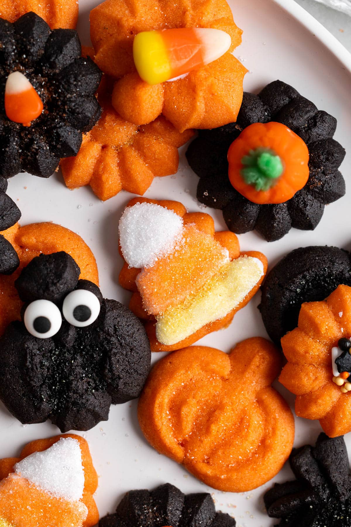 Baked Halloween color spritz cookies, including a triangle shape decorated as a candy corn.