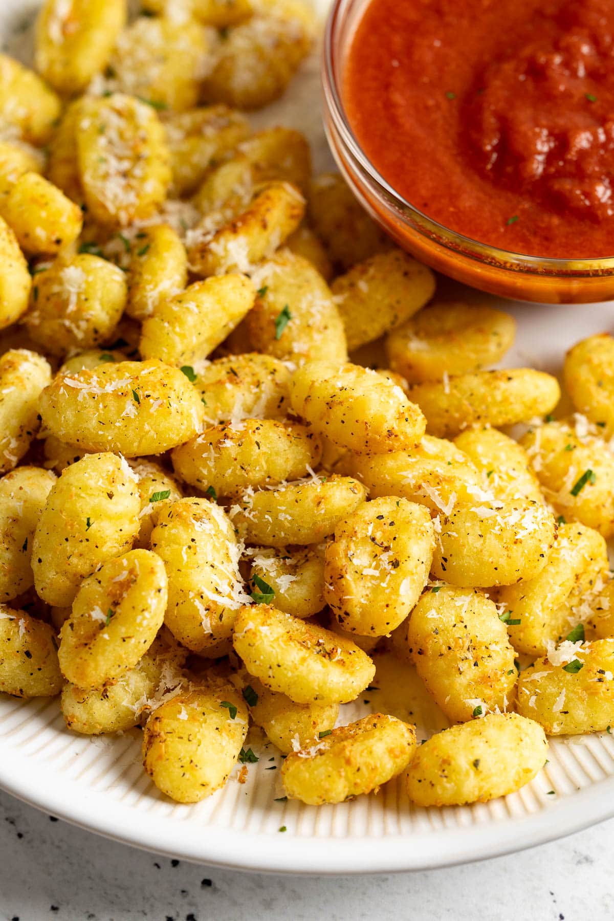 Crispy air fryer gnocchi sprinkled with shredded Parmesan.