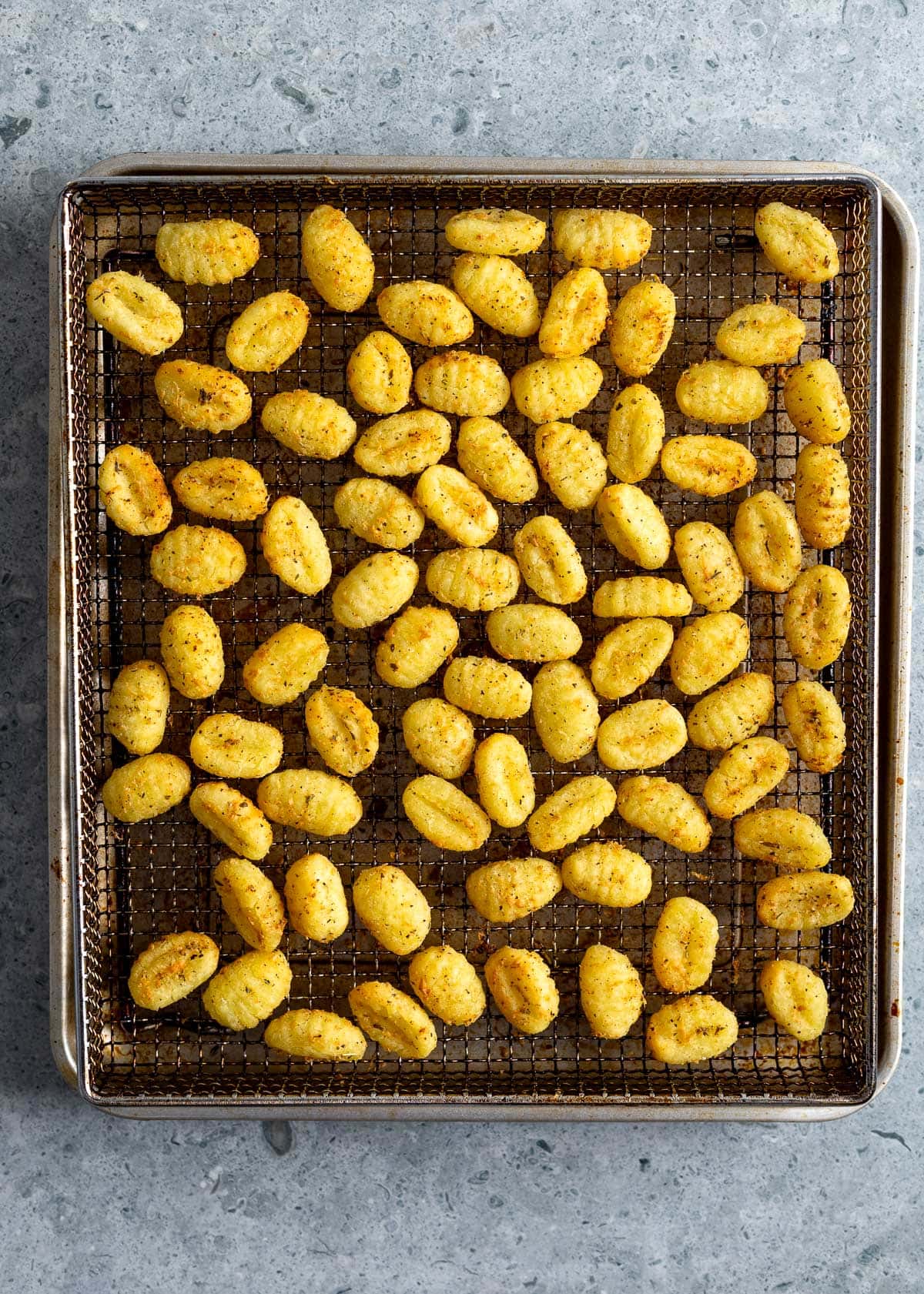 Crispy air fried gnocchi on the wire basket after being cooked.