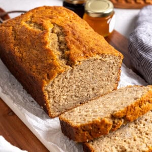 A partially-sliced loaf of Bisquick banana bread on a board.