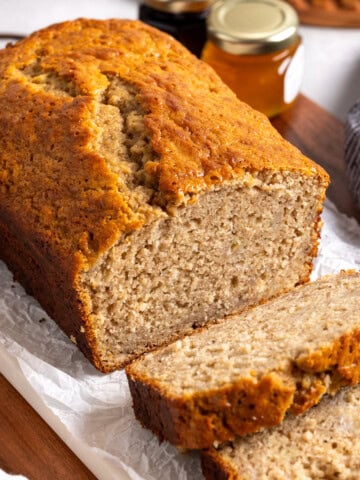A partially-sliced loaf of Bisquick banana bread on a board.