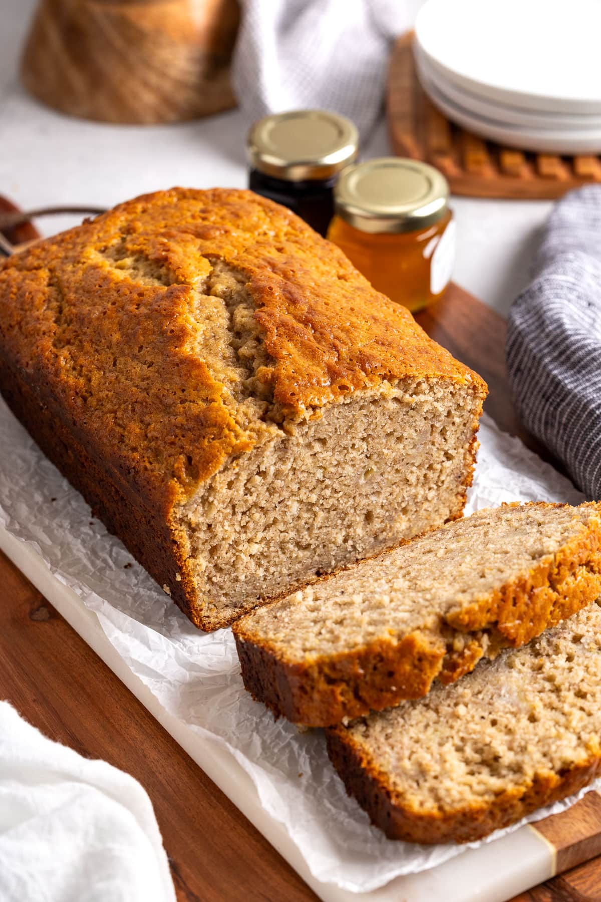 A partially-sliced loaf of Bisquick banana bread on a board.