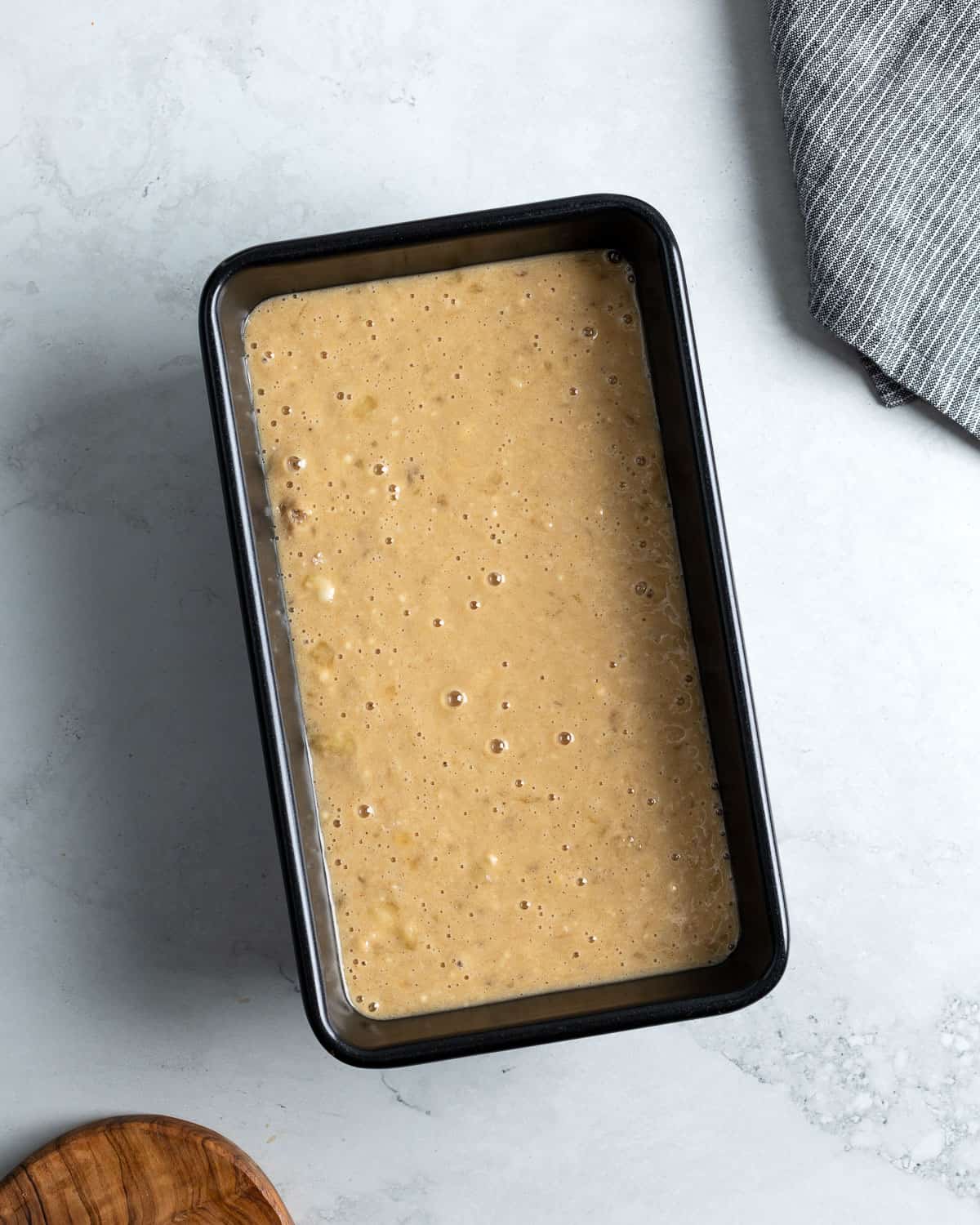 Banana bread batter poured into a loaf pan.