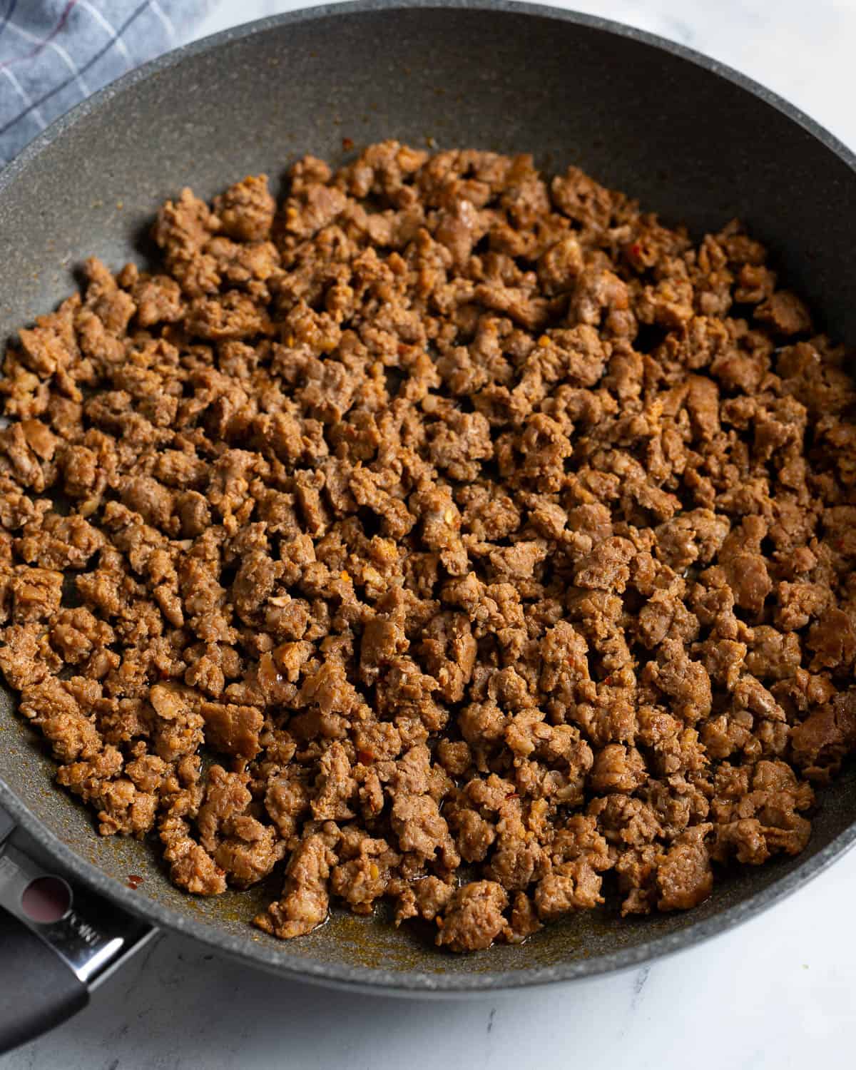 Cooked and crumbled chorizo in a skillet.