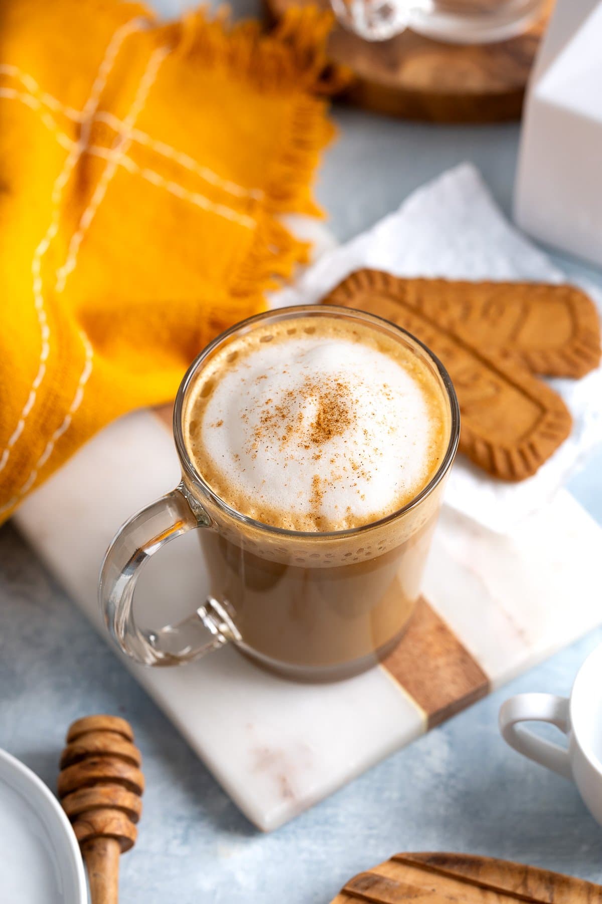 One cookie butter latte topped with foamed milk and a cinnamon sprinkle.