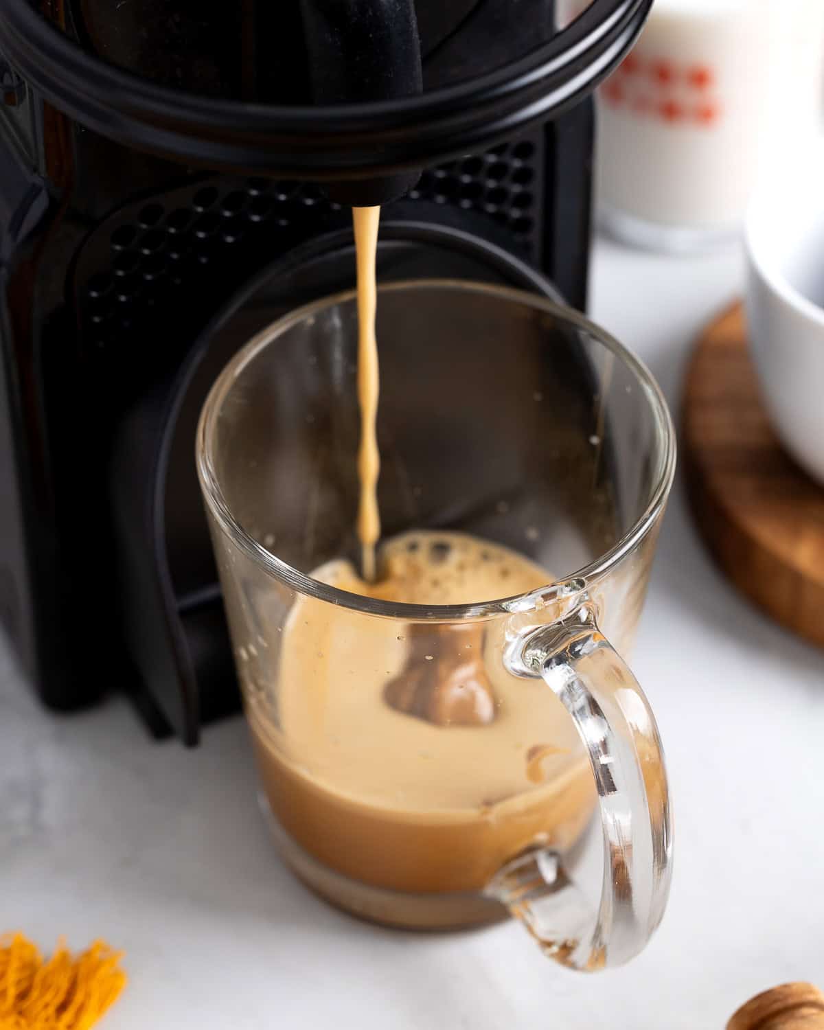 Espresso being brewed right into a mug with cookie butter in the bottom.