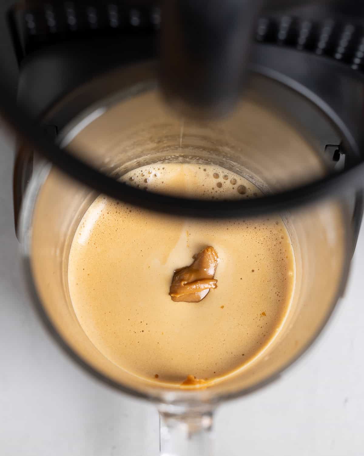 Hot espresso sitting to melt the cookie butter in a glass mug.